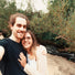 couple stands by a river and take a selfie